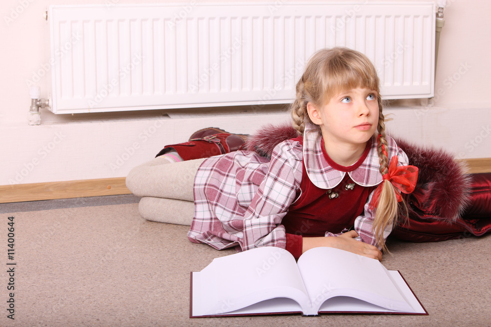 Girl lie on floor near radiator with book. Girl lie on floor near radiator with book.