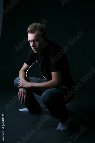 intense looking young man crouching