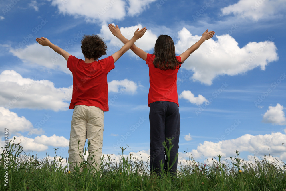 Kids holding arms up in praise against blue sky Kids holding arms up in praise against blue sky