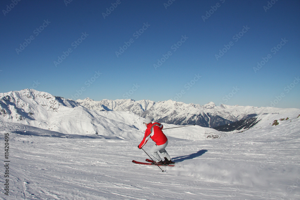 Skifahrer auf Piste mit Bergpanorama