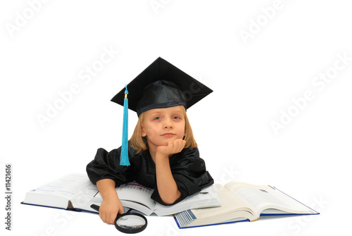 Cute little girl in graduation dress is reading books
