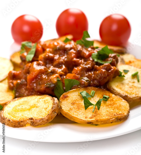 roasted potatoes with meat tomato sauce on a white plate