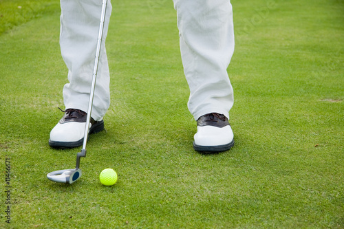 Golf player in special shoes on a putting green