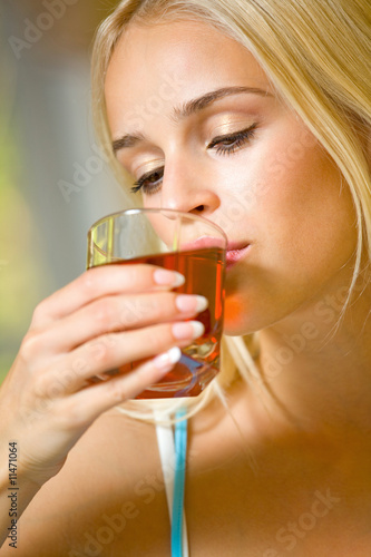 Portrait of young beautiful woman with glass of juice, indoors