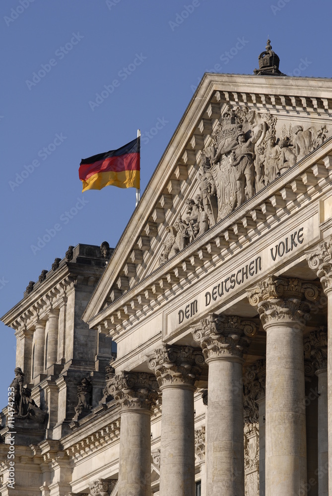DEM DEUTSCHEN VOLKE. Deutscher Reichstag mit wehender Flagge im Sonnenlicht am späten Nachmittag