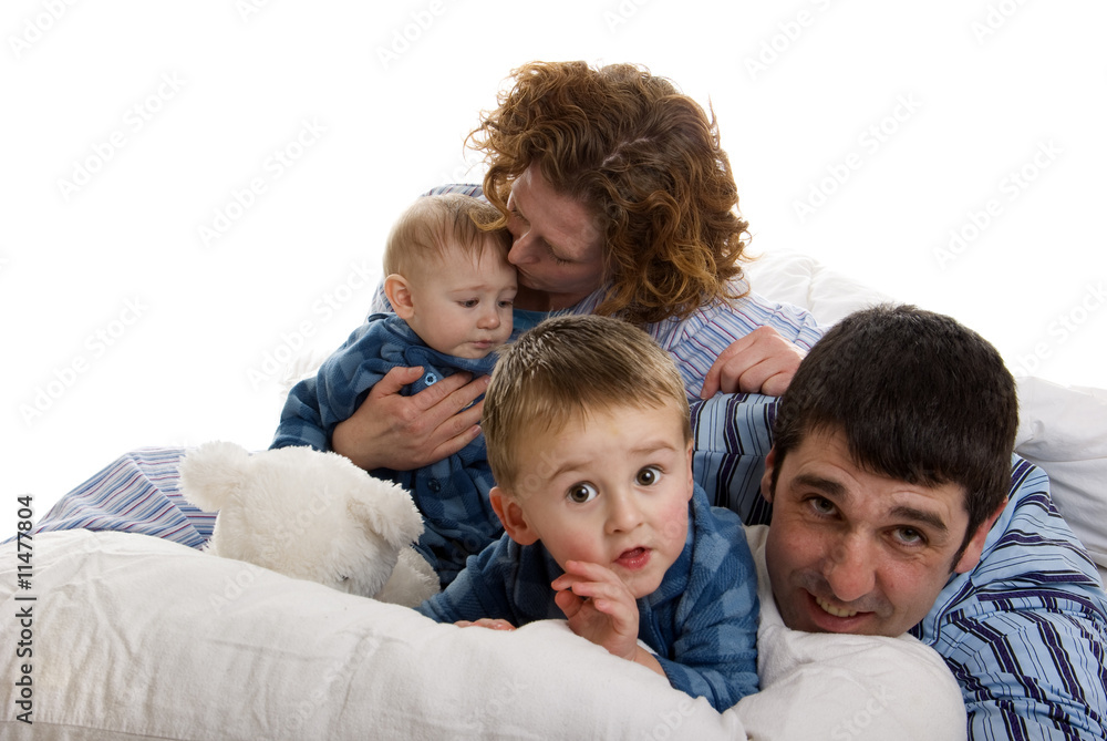 Family of four relaxes in bed