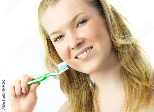 young blond woman brushing her teeth