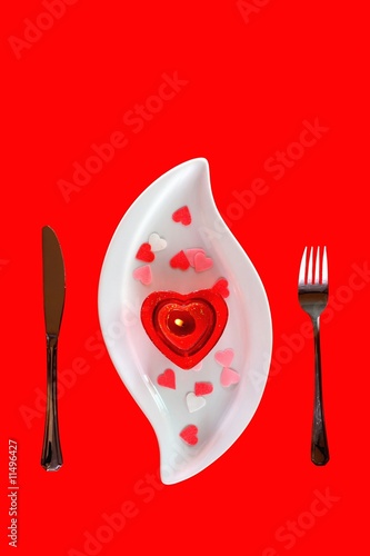 Candle on white plate and red background
