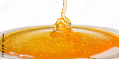 Fotografía Macro picture of honey dripping on a glass plate