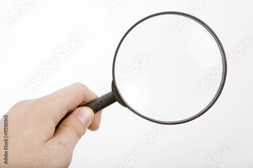 The hand holds a magnifier