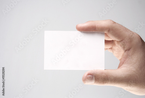Mão segurando um cartão pessoal branco