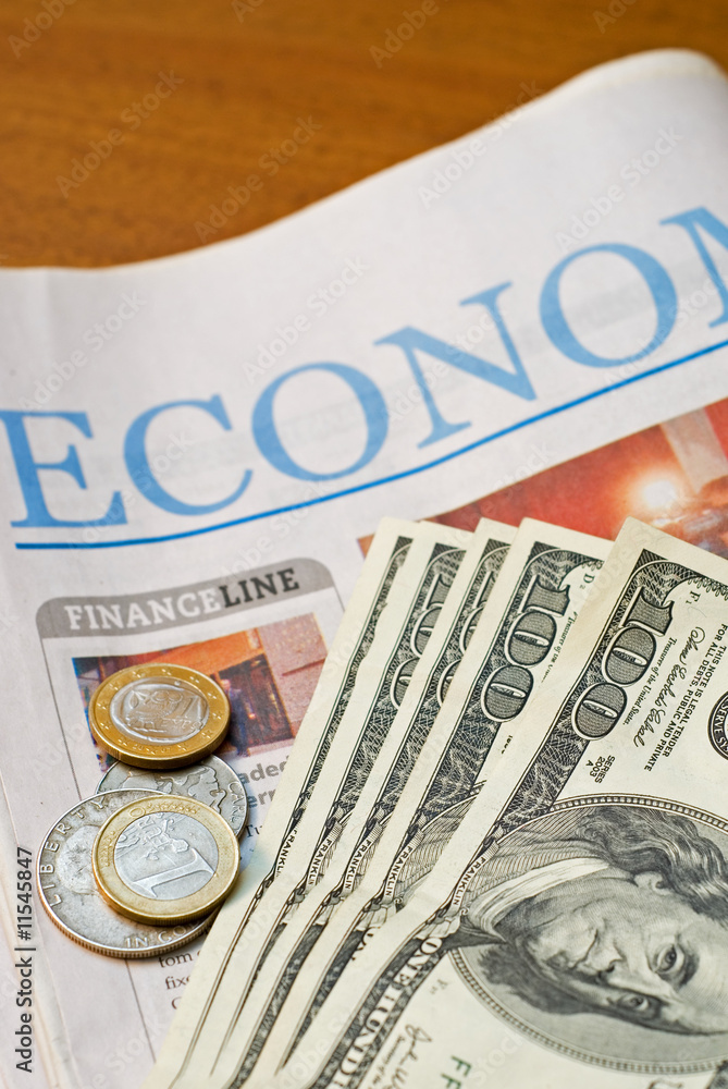 Obraz premium Financial Newspaper with heap of one hundred dollars and coins