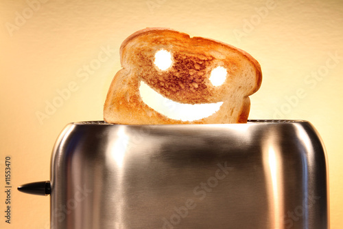 Toast with smiley face in toaster  on counter