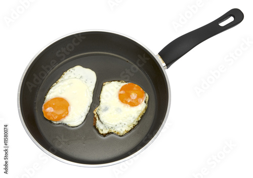 Fried eggs on non-stick pan isolated on white