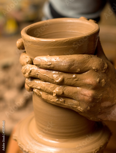 Close up of hands of the potter creating utensils