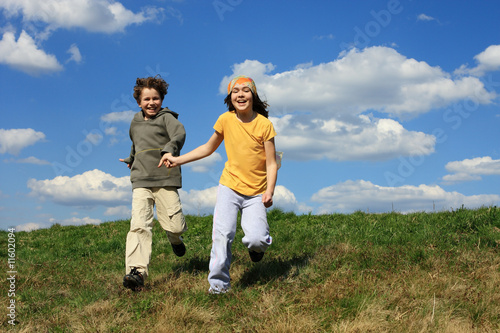 Kids jumping, running against blue sky