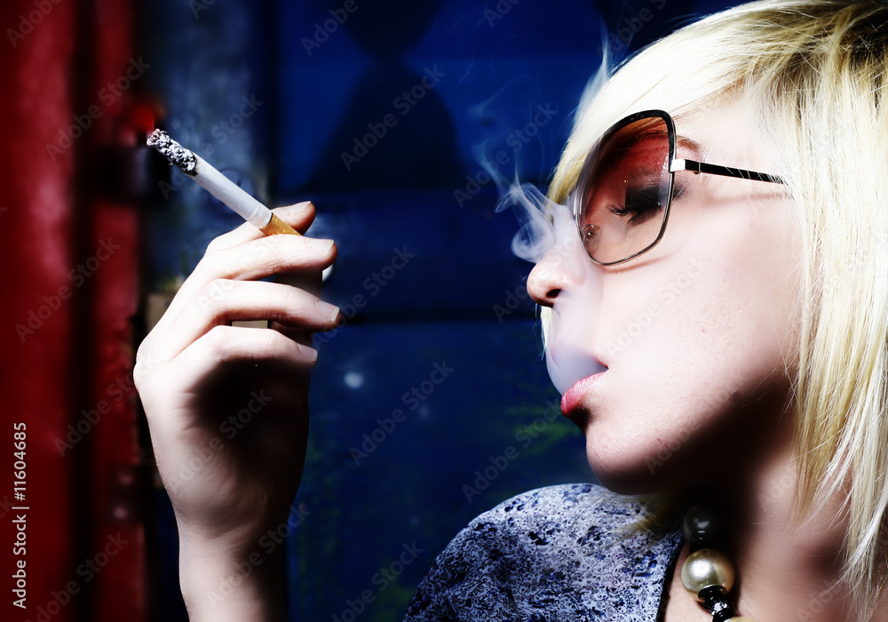 Obraz premium The beautiful girl smokes a cigarette