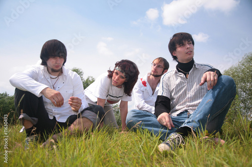 Group of friends sit on grass