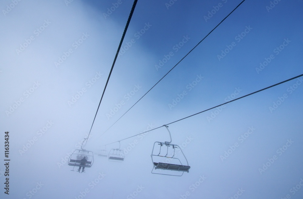 Chairlift disappearing into fog Chairlift disappearing into fog