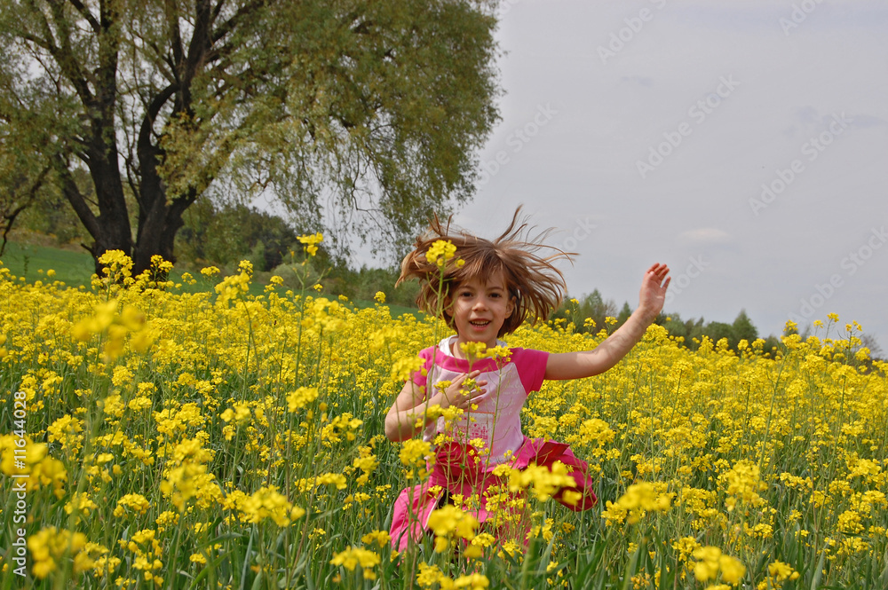 Fototapeta premium Happy girl jumping on canola field