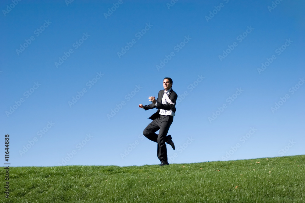 Businessman running in the field Businessman running in the field