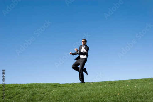 Businessman running in the field