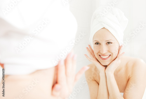 happy woman looking at her reflection in the mirror