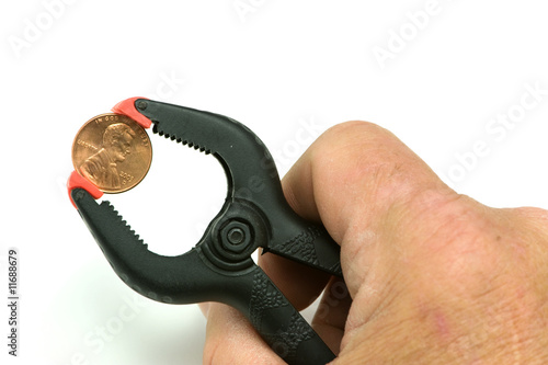 Hand gripping penny with clamp