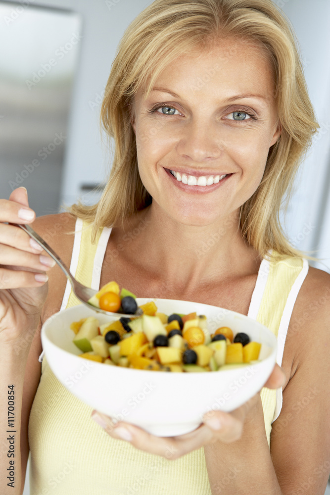 Mid Adult Woman Eating A Bowl Of Fresh Fruit Mid Adult Woman Eating A Bowl Of Fresh Fruit