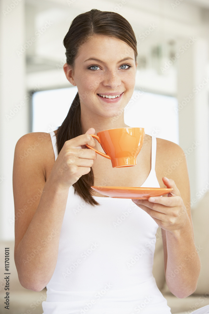 Young Woman Drinking Out Of An Orange Cup Young Woman Drinking Out Of An Orange Cup