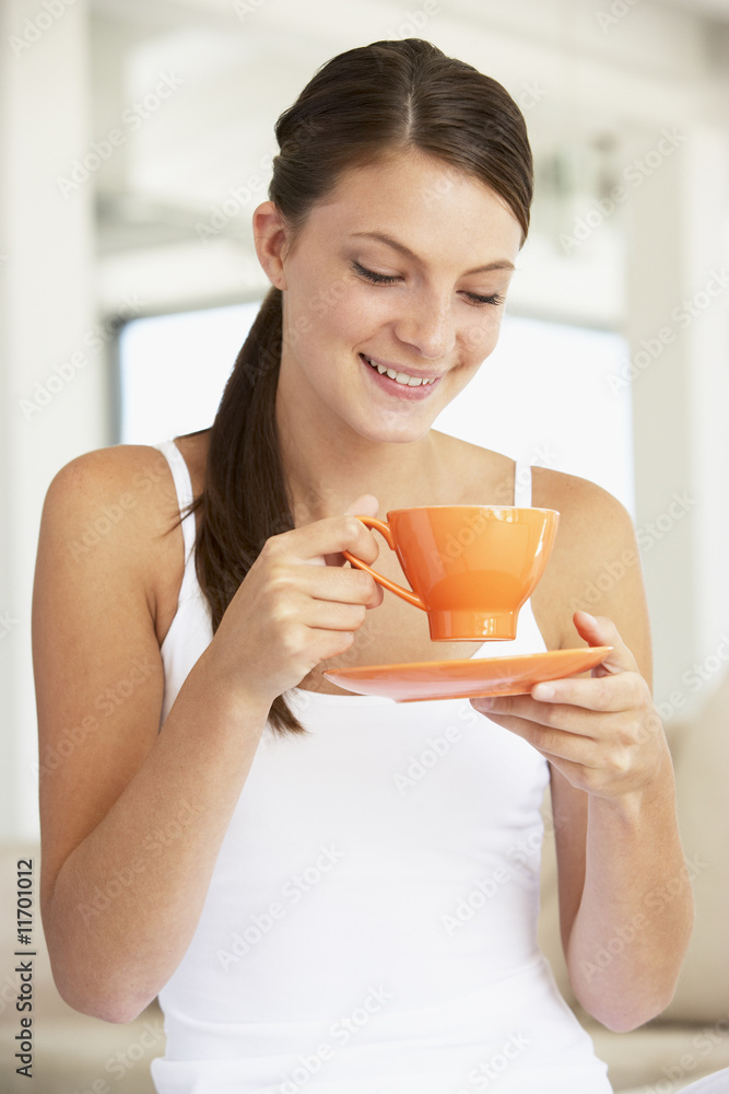 Young Woman Drinking Out Of An Orange Cup Young Woman Drinking Out Of An Orange Cup