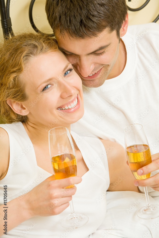 Young couple celebrating with champagne at bedroom Young couple celebrating with champagne at bedroom