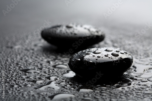 black shiny zen stones with water drops over black background #11718418