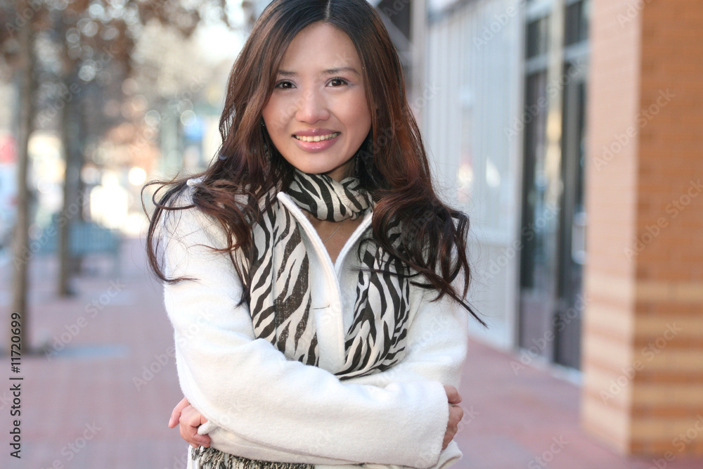 Fototapeta premium Winter Theme - Beautiful Asian Girl in White Coat and Scarf Smil