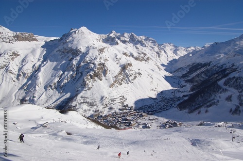 winter mountain landscape with skiers goind down