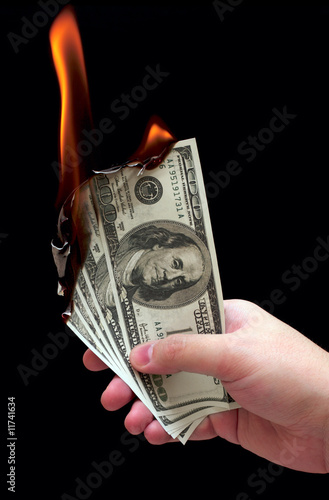 Burning dollars in a hand
