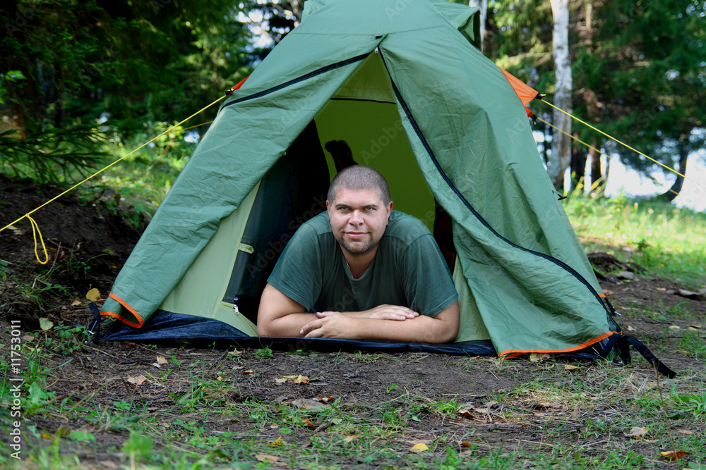 big smiling man in camping tent