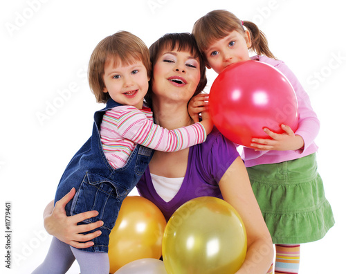 Mother and his two daughters with colorful balloons.