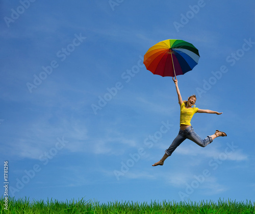Flying girl with colorful umbrella on the blue blue sky
