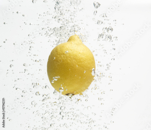 Alone lemon is dropped into fresh water.