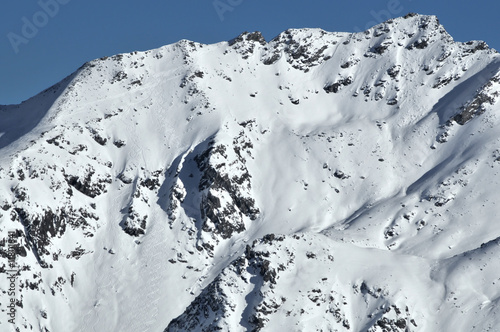 Skiing turns in powder snow on a steep mountain
