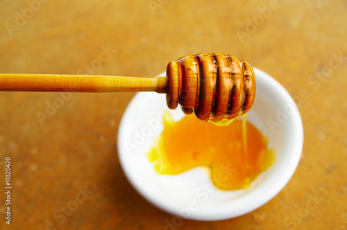 honey being dripped into a white bowl