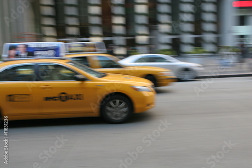 Fast driving yellow cabs (Taxi car) in Manhattan on Fifth Avenue, New York City, USA
