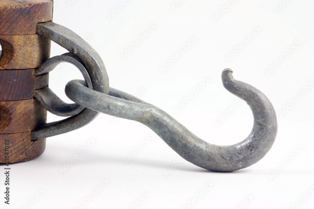 Obraz premium Antique block and tackle hook for hoisting heavy objects.