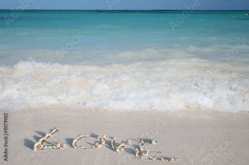 Fotografia Word Love on Beach Sand on White Sand Beach and Green Ocean