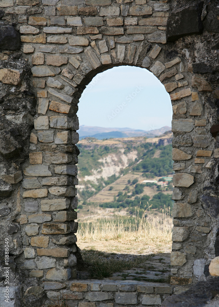 Ancient stone doorway of medieval castle ruin on hill