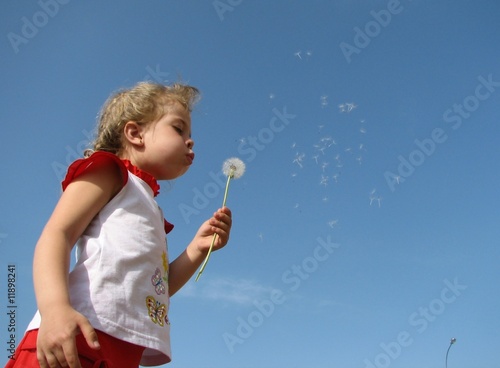 Girl blowing a seedy dandelion