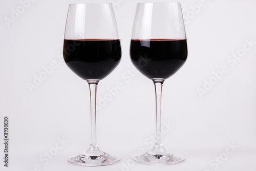 Two glass side by side with red wine. White background . Copy space.