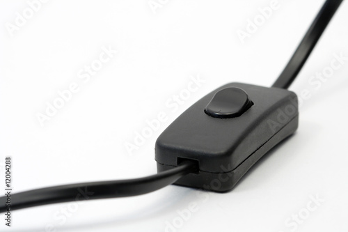 Black electric cable with switch lying on white background
