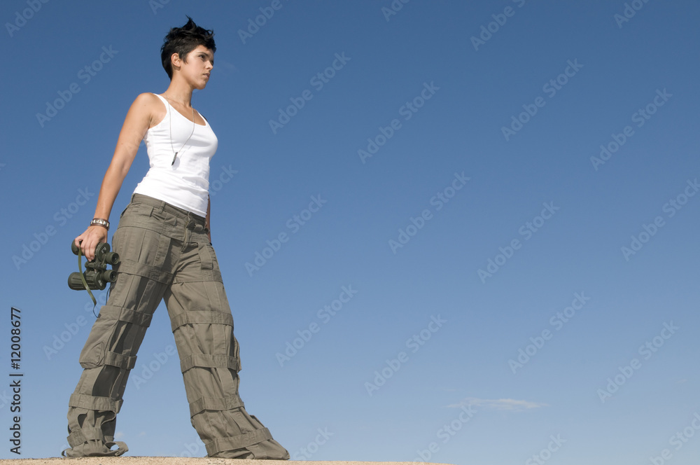 Beautiful girl in military clothes and binoculars in blue Beautiful girl in military clothes and binoculars in blue